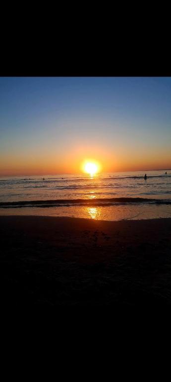 a sunset on the beach with the sun setting at Canela in Atlántida