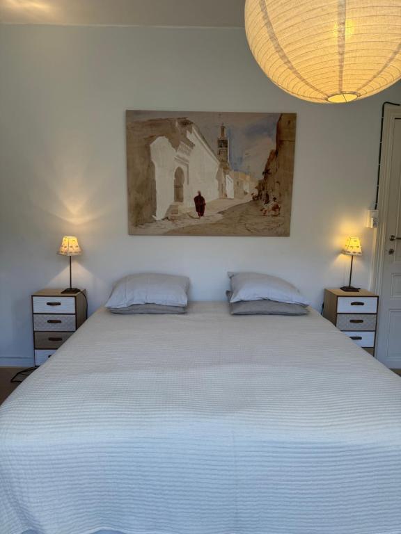 a bedroom with a large white bed with two lamps at Huyze Elise Free Parking in Ostend