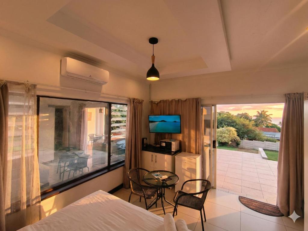 a bedroom with a bed and a table and chairs at Da Vinci - Zur See in Ballito