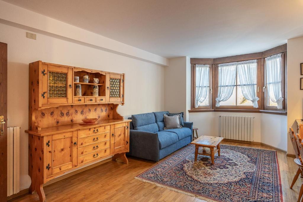a living room with a blue couch and a wooden cabinet at Casa Tre Corone, sulla strada per Cortina in Borca di Cadore