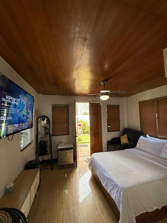 a bedroom with a bed and a flat screen tv at Villa with Beachfront Access in Lalauigan