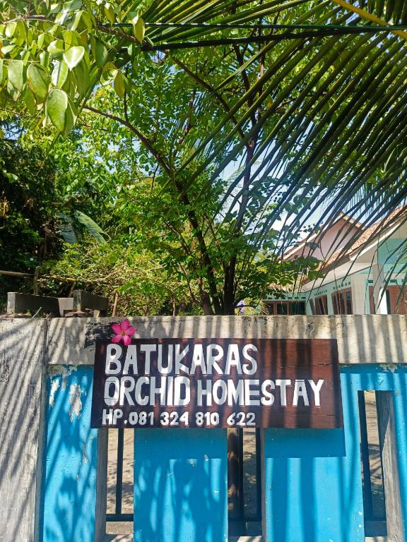 a sign on a fence in front of a house at BATUKARAS Orchid Homestay in Batukaras