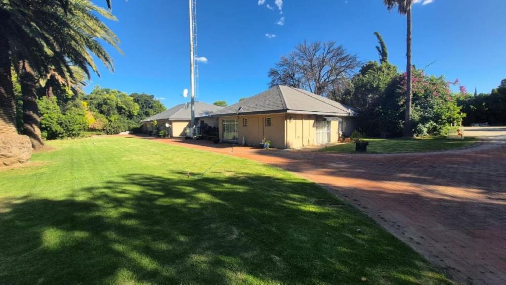 a house in a field with a grass yard at Silhouette Guesthouse in Welkom
