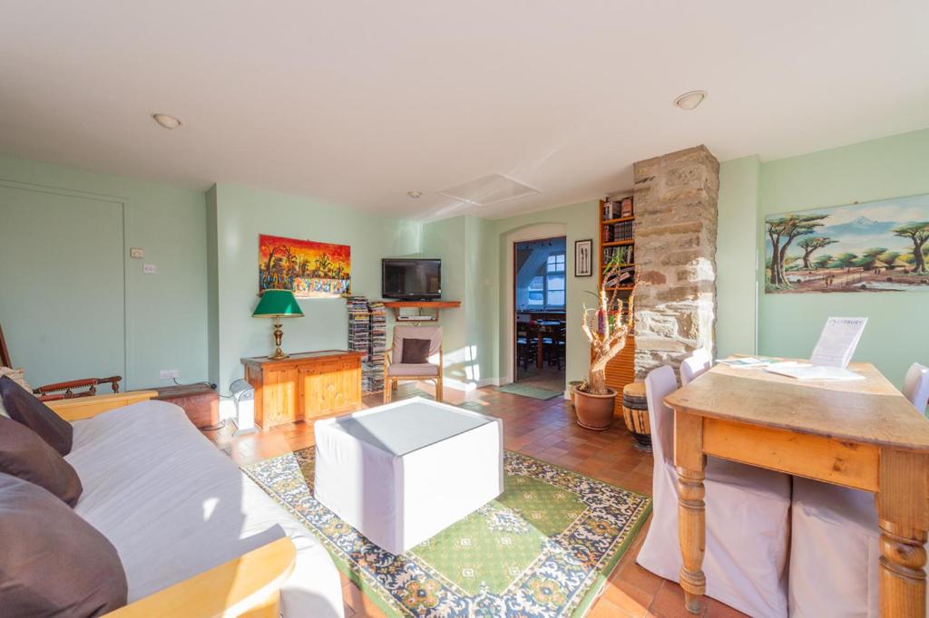 a living room with a couch and a table at Kwerky Cottage in North Lydbury