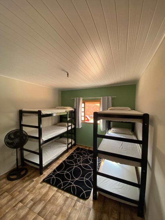 two bunk beds in a room with a ceiling at Hostel Canaã in Itanhandu