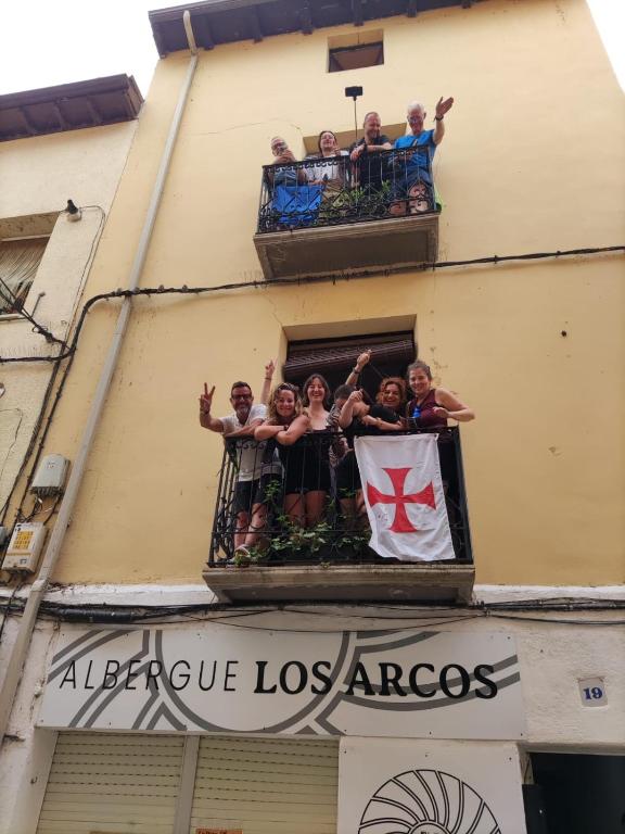 a group of people on a balcony with a flag at Albergue Los Arcos-solo para peregrinos- in Los Arcos