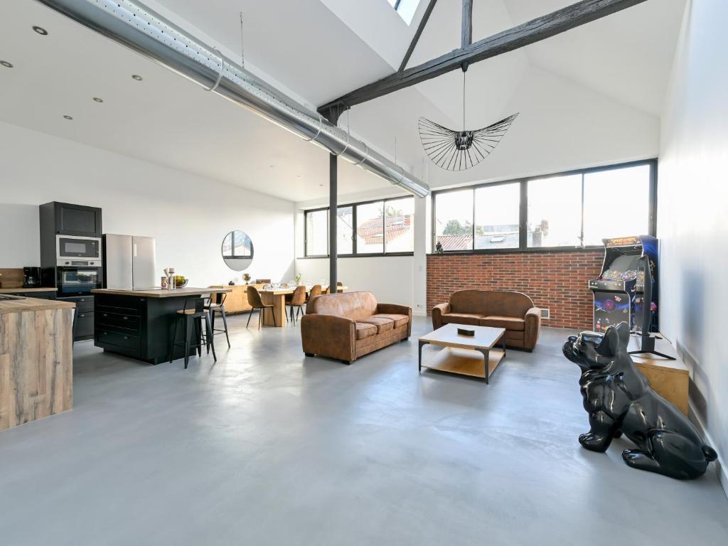 a large living room with couches and a kitchen at Climatisé et atypique, bienvenue au LOFT-23 in Cholet