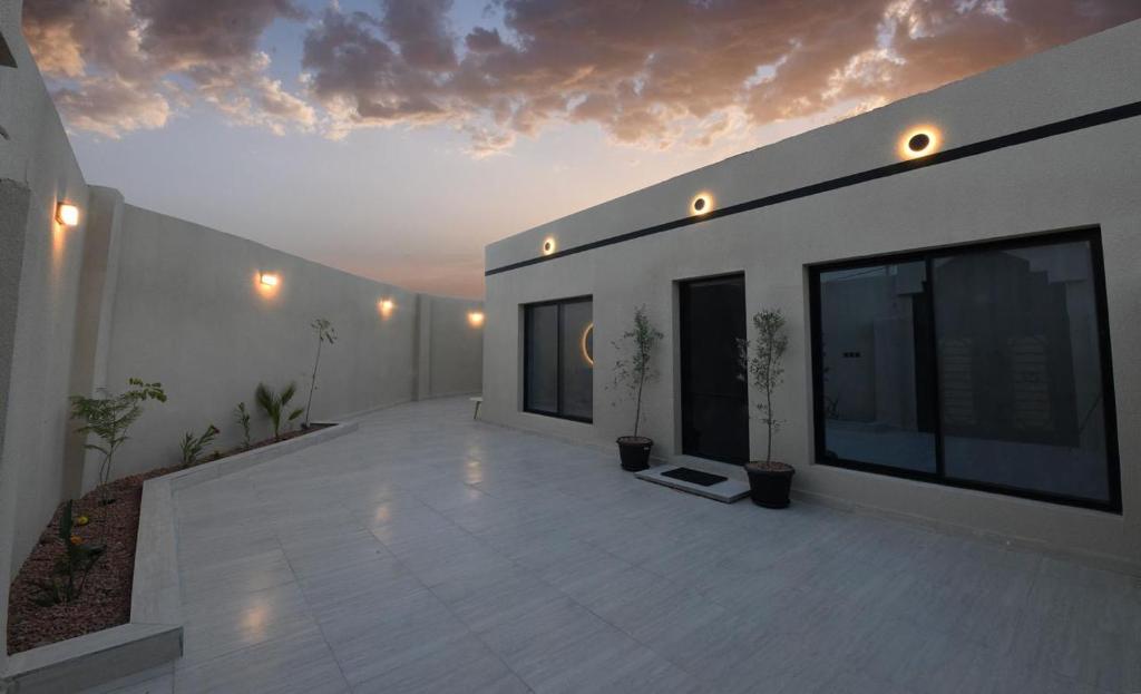 a large white building with a large patio with plants at شقة مشراق in Al-ʿUla