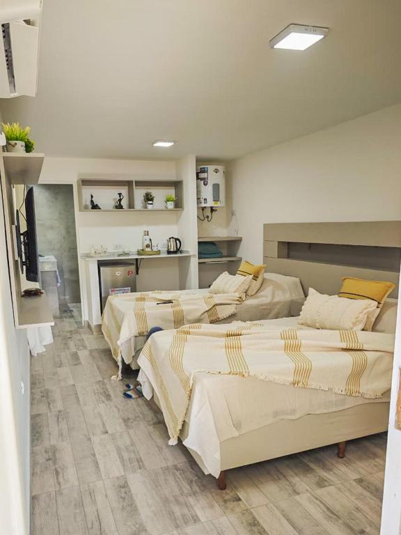 a room with three beds in it with a kitchen at Suite de Lujo Castañitas in Tafí del Valle