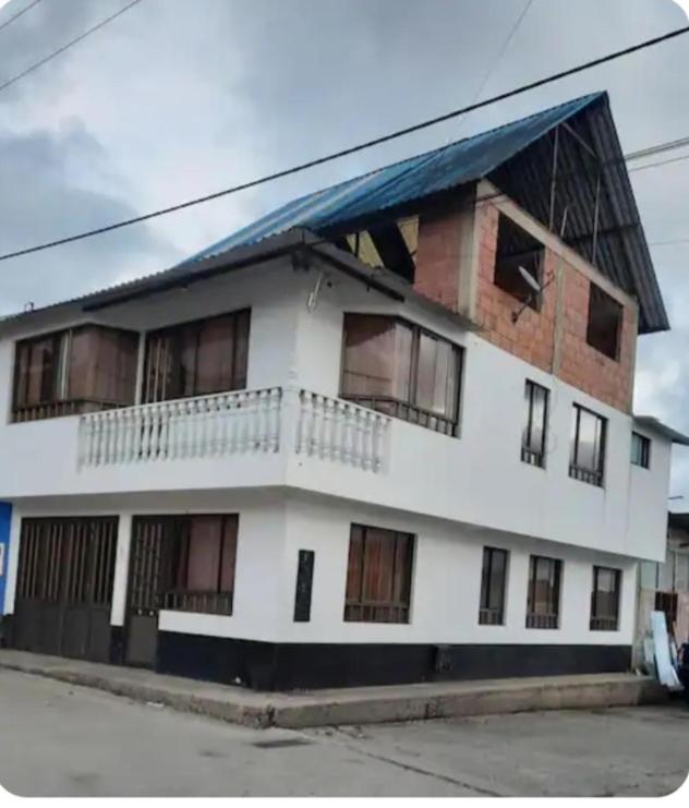 a white building with a blue roof at Apartamento Macanal in Macanal