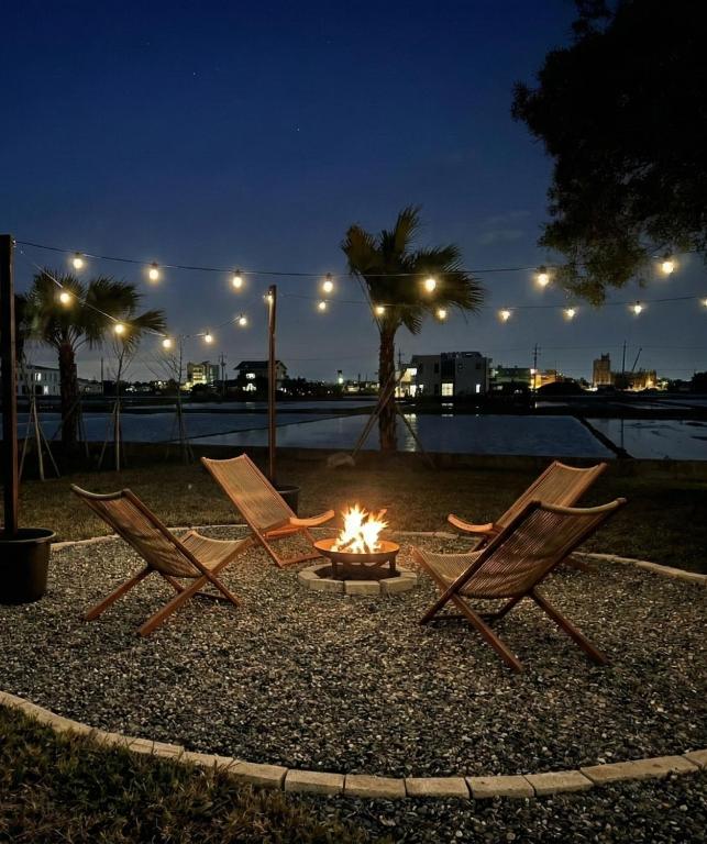 a group of chairs around a fire pit at night at OFFLand 遺忘無際 宜蘭 4-6人 小包棟民宿 in Wujie