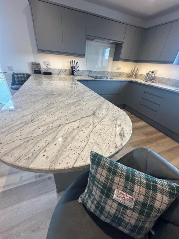 a kitchen with a marble table and two chairs at Perceval Road, Stornoway Town in Stornoway