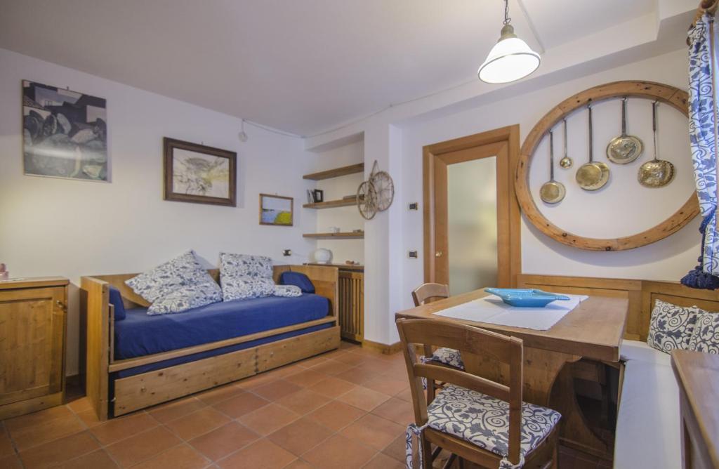 a living room with a bed and a table at Un angolo di relax sulle Dolomiti ampezzane in Cortina dʼAmpezzo