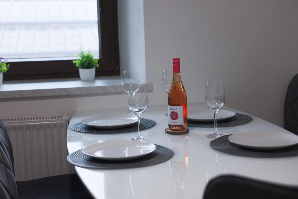 a table with two glasses and a bottle of wine at M&M apartma in Bohinj