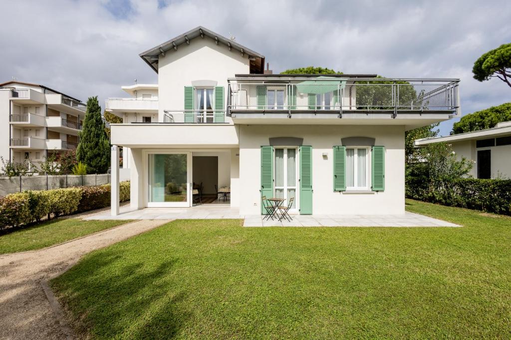 a white house with a balcony and a yard at Le Sabbie B&B - Camere in villino a 50mt dal mare in Riccione