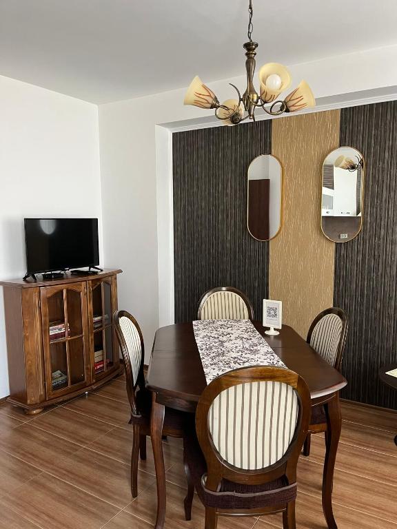 a dining room with a table and chairs and a television at Apart di Landi in Ravda