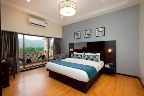 a bedroom with a large bed and a balcony at Castle in Bharatpur