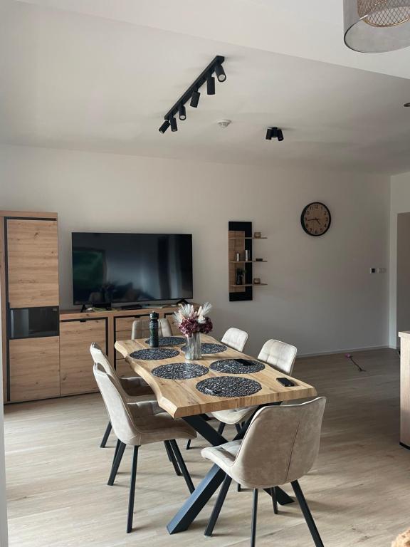 a dining room with a table and chairs and a tv at Apartmán #7 Mariánská Hora in Albrechtice v Jizerských horách