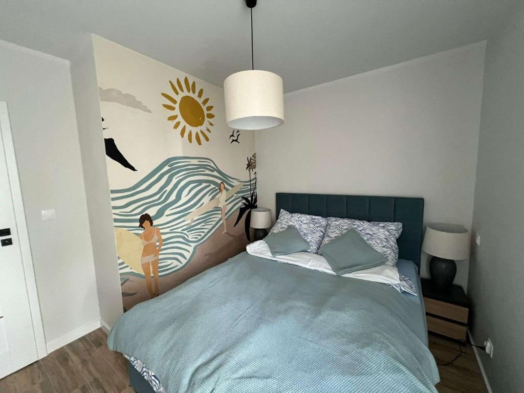 a bedroom with a bed with a painting on the wall at Mewa Studio in Krynica Morska