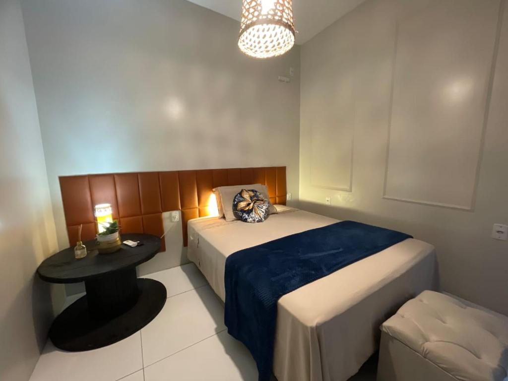 a small bedroom with a bed and a table at Vida & Brisa Pousada in Pelotas