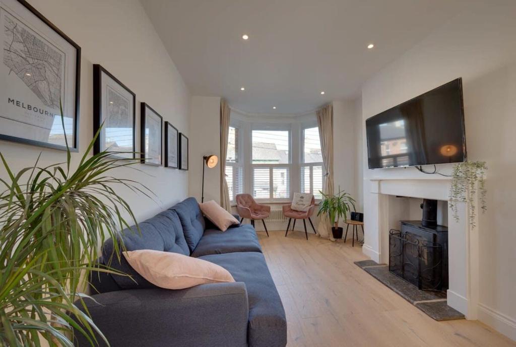 a living room with a blue couch and a fireplace at Modern & homely 2-bed - close to BEACH in Bideford