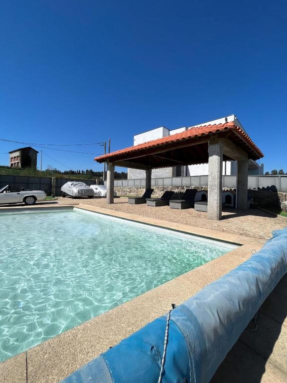 a swimming pool with a gazebo next to a swimming pool at Daisy Country House in Lousada