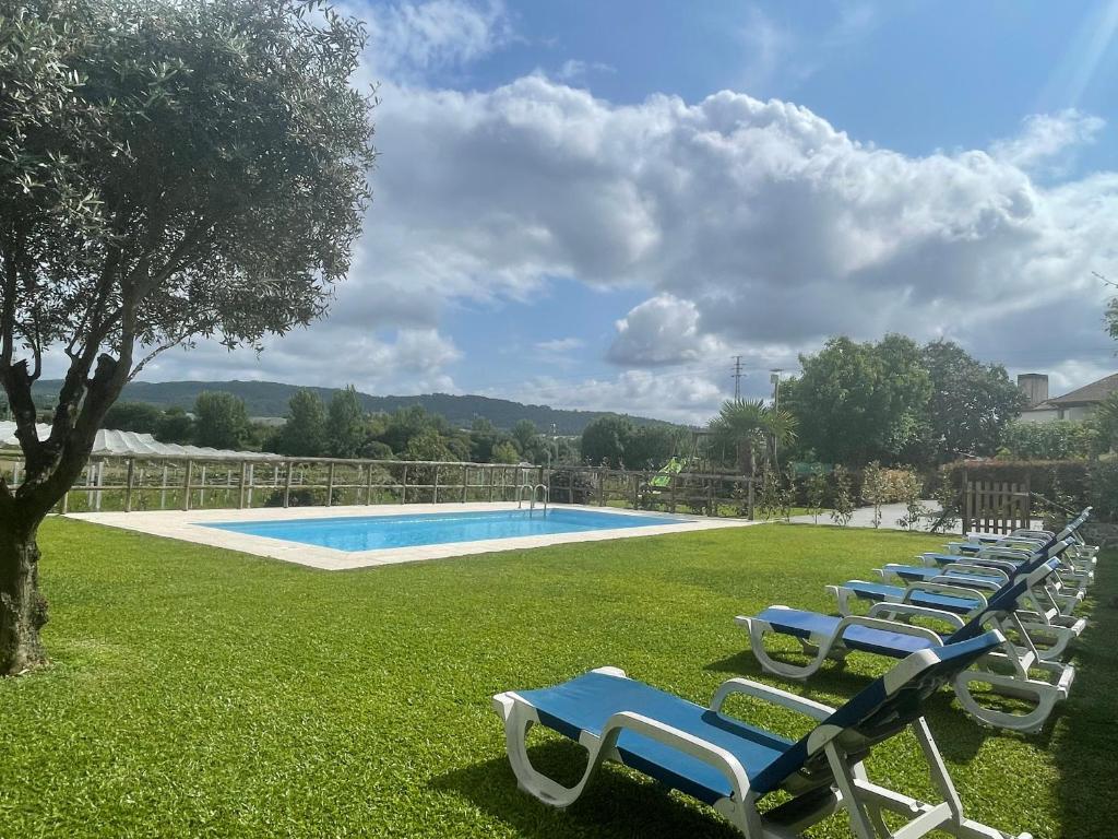 a row of lounge chairs next to a swimming pool at Quinta do Sobrado in Braga