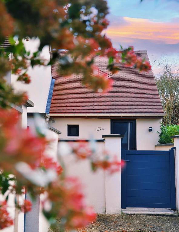 a white house with a blue garage door at Au Charme De Bussy - Maison proche Disney avec terrasse et parking in Bussy-Saint-Georges