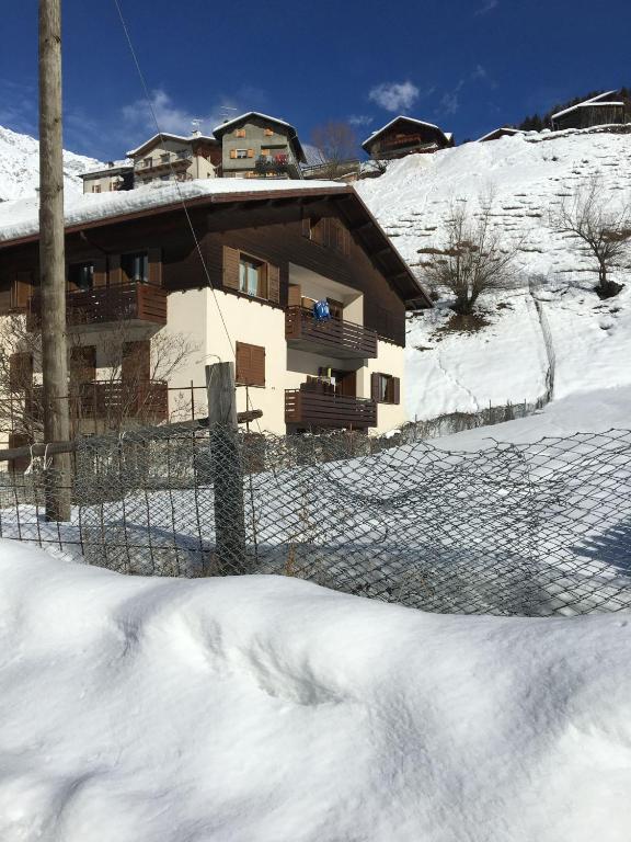 a building with a fence in the snow at Ca' Delle Nevi in SantʼAntonio