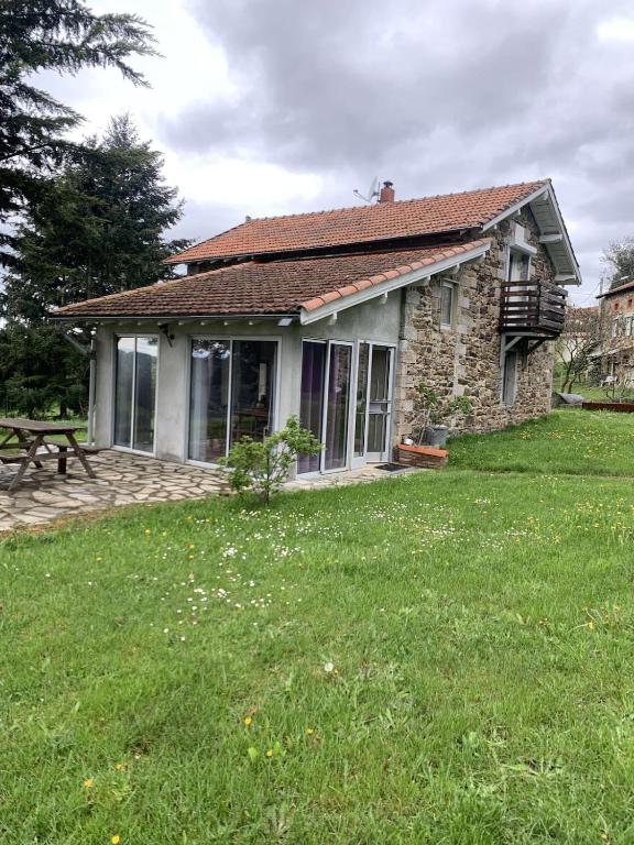 a small stone house with a picnic table in a yard at Maison de caractère in Saint-Vert