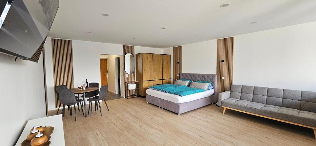 a bedroom with a bed and a couch and a table at Ferienwohnung Nideggen, Eifel, Nähe Ruhrsee, Nationalpark in Nideggen