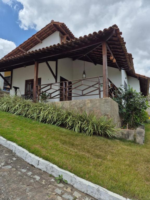 a white house with a brown roof at Casa Baraúnas 05 in Gravatá