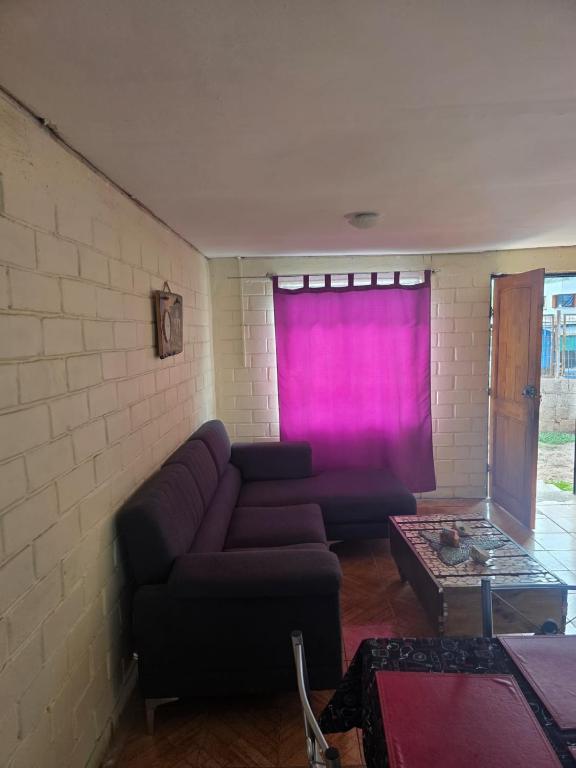 a living room with a couch and a pink curtain at Margaret in Combarbalá
