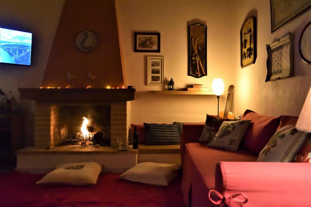 a living room with a fireplace and a couch at Holiday Cottage in Lílaia