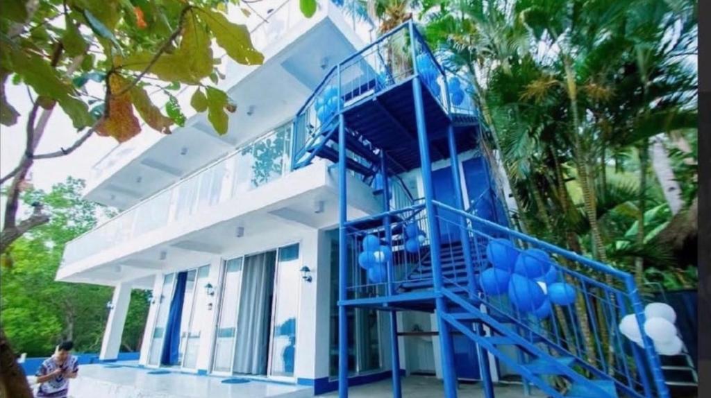 a house with a blue staircase in front of it at Taguilon Hidden Beach Cove Resort in Dapitan