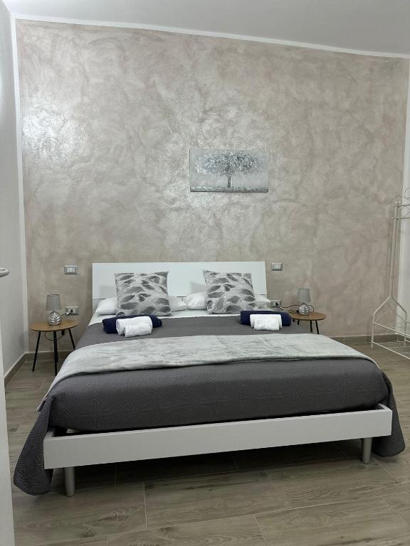 ein Schlafzimmer mit einem großen Bett vor einer Wand in der Unterkunft S'Istella Affittacamere in Tinnura