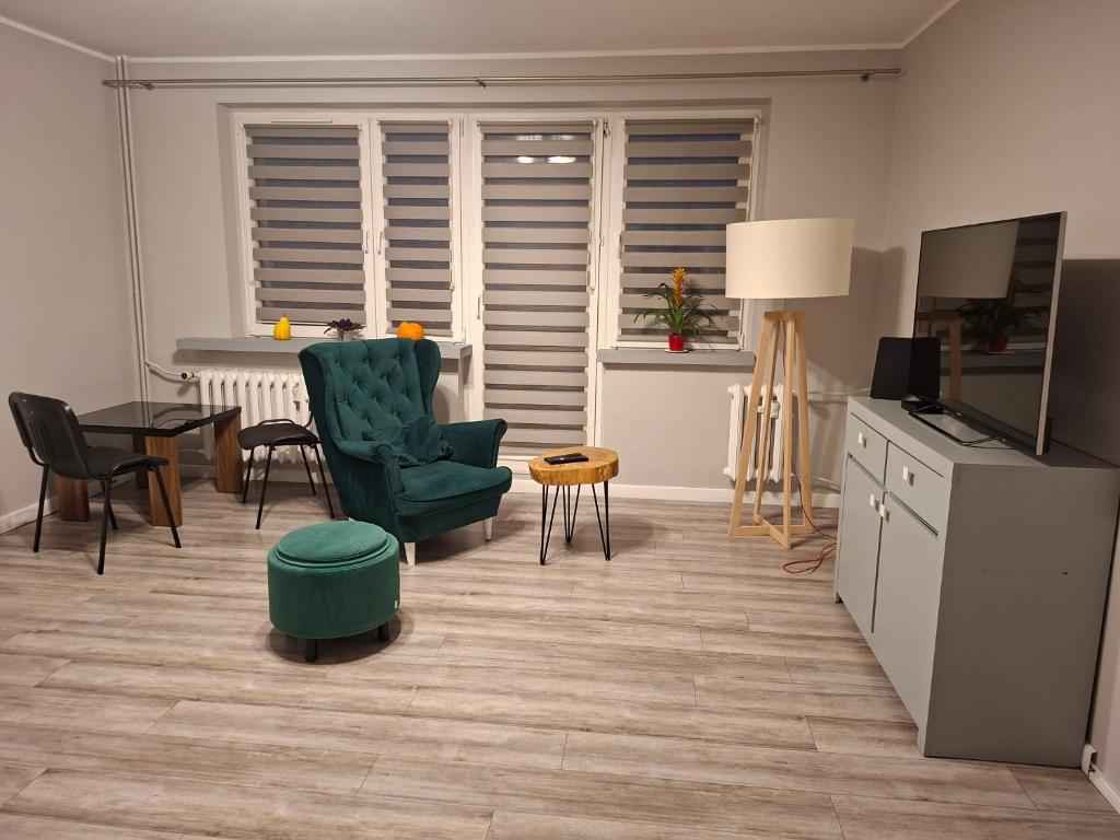 a living room with a green chair and a table at Piąteczka in Pniewy
