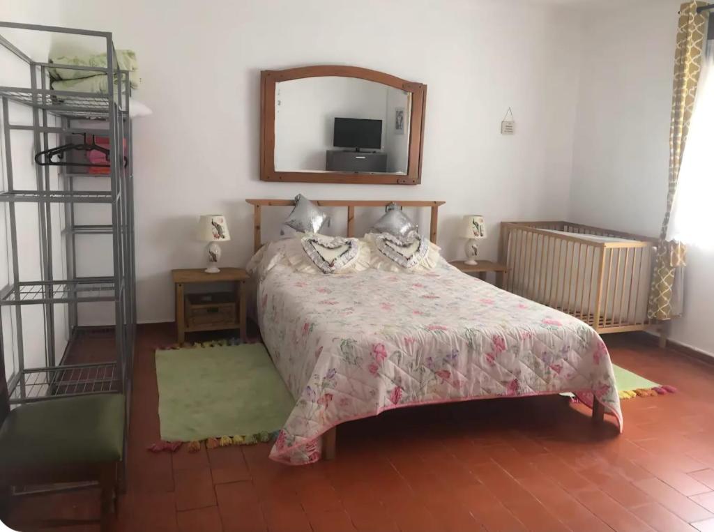 a bedroom with a bed and a mirror at The Lemon Tree House in Quinta do Conde