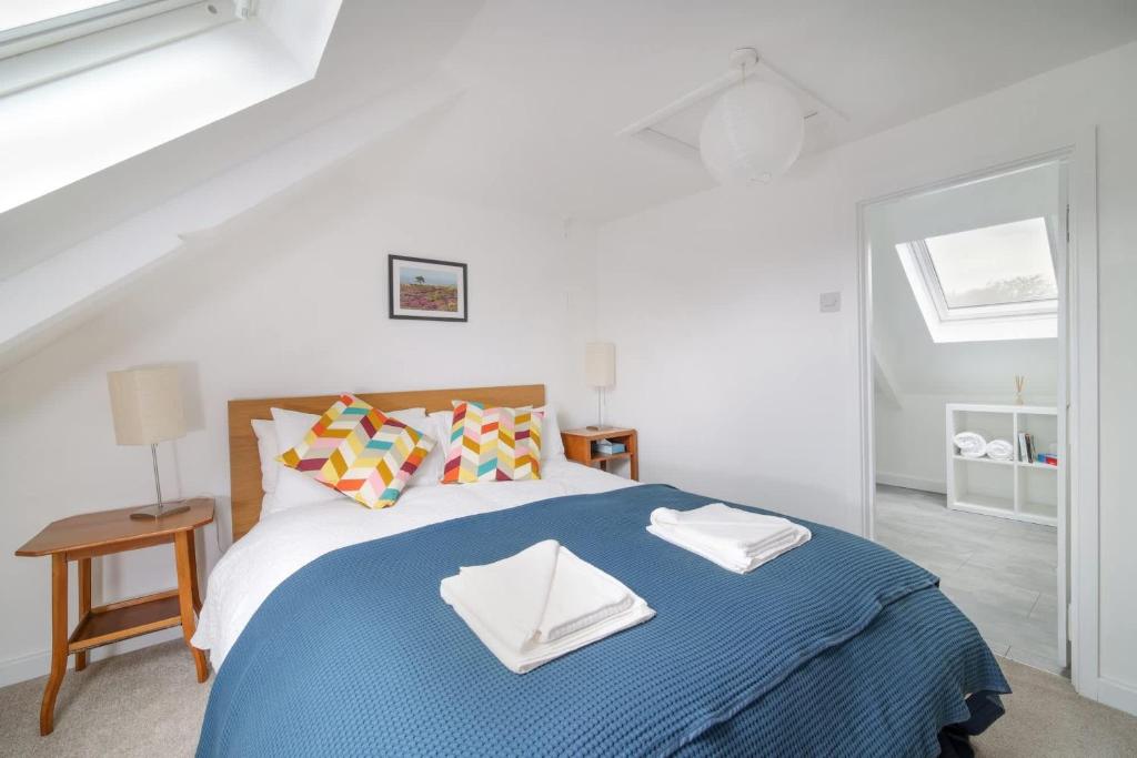 a bedroom with a bed with a blue blanket at Beautiful Cottage & Garden Quantock Hills in Nether Stowey