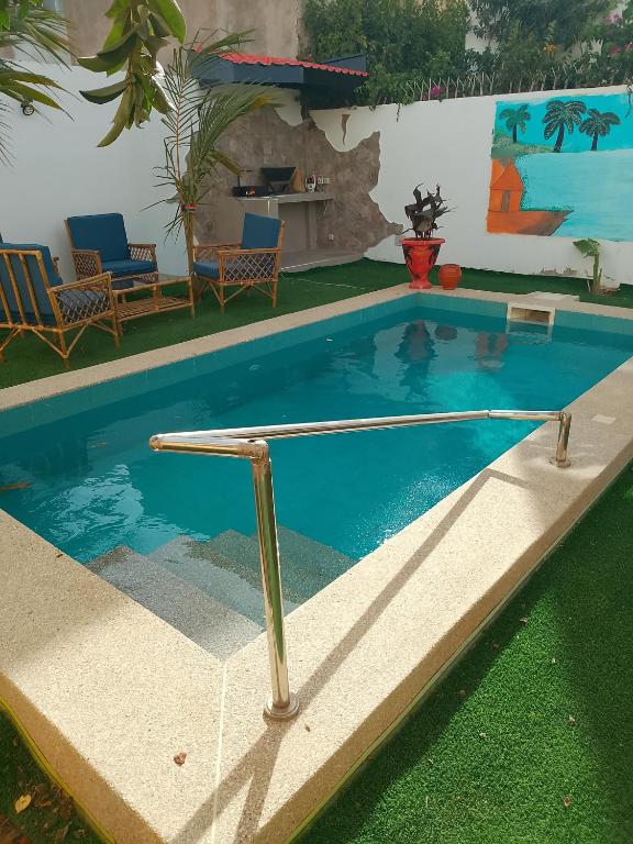 a swimming pool with a metal rail in a yard at Villa Sara DIALLO in Ngaparou