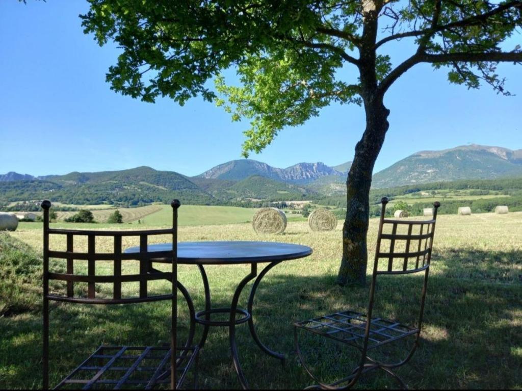 a table and two chairs sitting next to a tree at L'Etape de Charme in Bourdeaux
