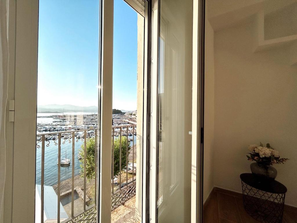 a room with a balcony with a view of the ocean at EDIFICI ROSA- Ático primera línea in Port de la Selva
