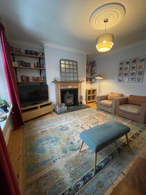 a living room with a couch and a tv at Historic Highland Townhouse in Fort William
