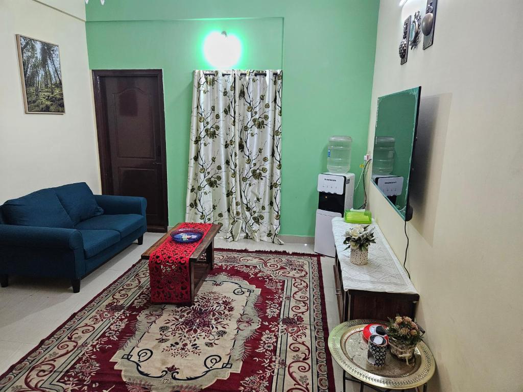 a living room with a blue couch and a rug at Rove Haven Condo in Bangalore