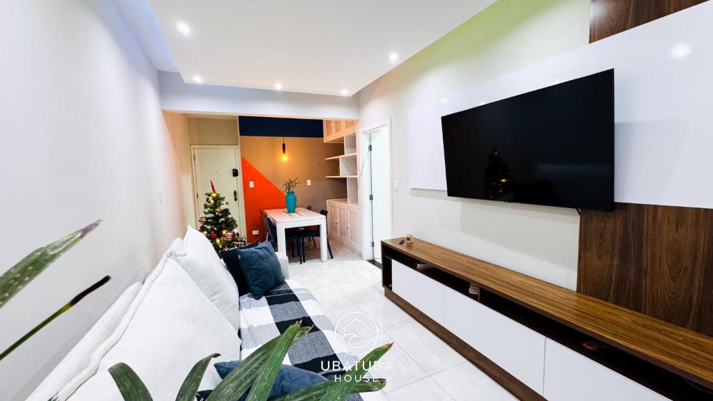 a living room with a large flat screen tv on a wall at Apartamento Centro Ubatuba - Ubatuba House Temporada in Ubatuba