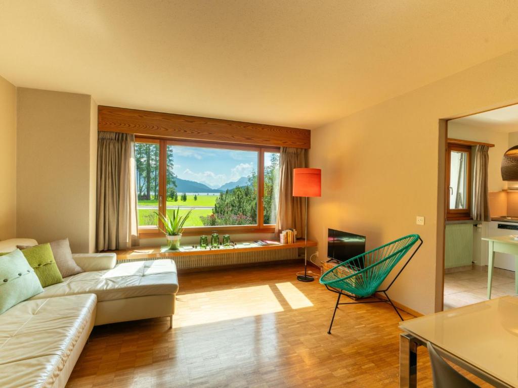 a living room with a couch and a large window at Apartment Chesa Tscheppa 1 by Interhome in Sils Maria