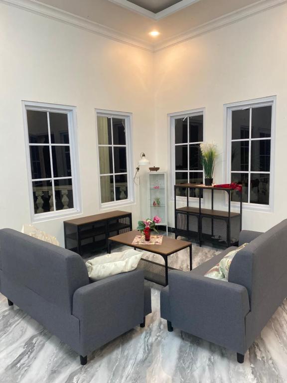 a living room with two couches and a table at Laura villa in Cisarua