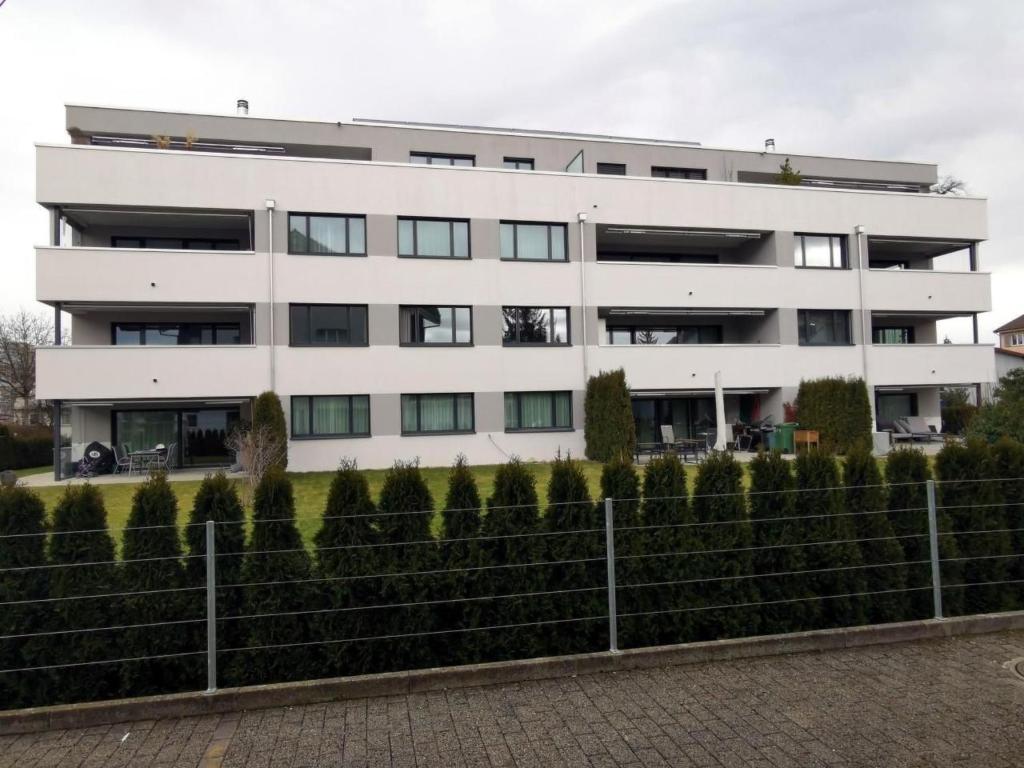 a white building with a fence in front of it at Apartment HIRSCHEN by Interhome in Gossau