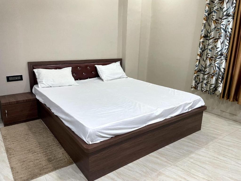 a bed with white sheets and pillows in a bedroom at Indian Happy Homes in Siar