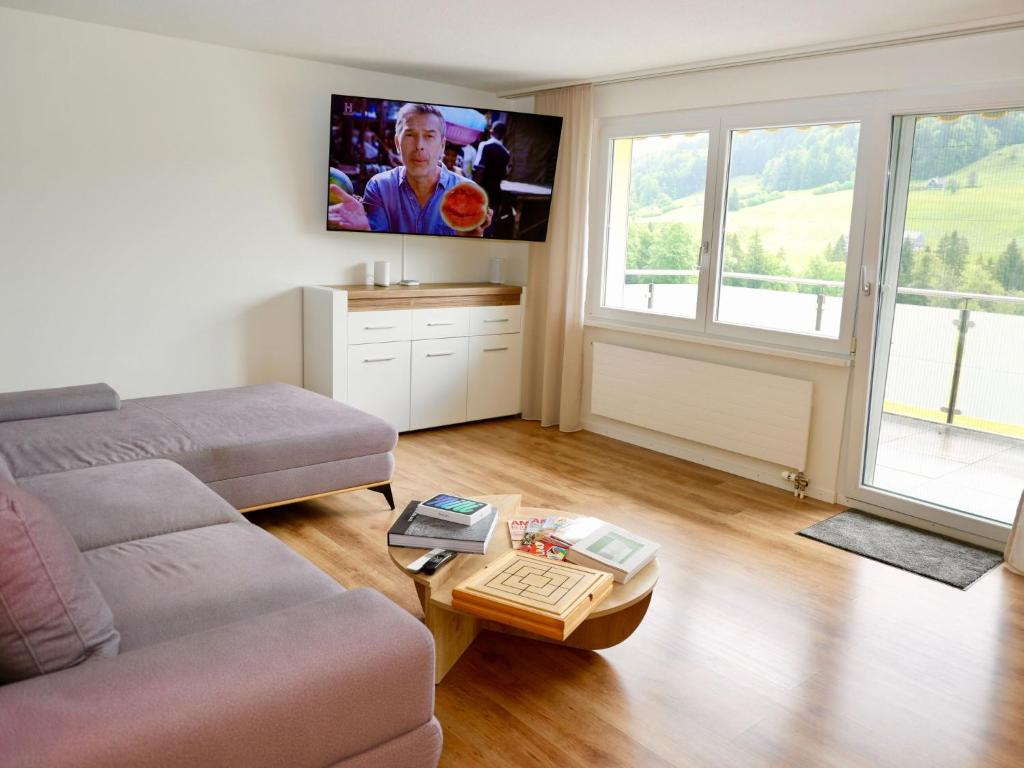 a living room with a couch and a flat screen tv at Apartment Panoramablick by Interhome in Nesslau
